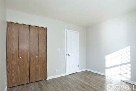 A room with a white door and wooden cabinets.