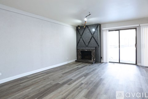 A room with a fireplace and wooden flooring.