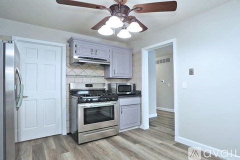 A kitchen with a refrigerator, stove, oven, microwave, and cabinets.