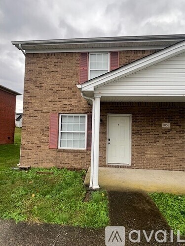 A brick house with a white door and window.