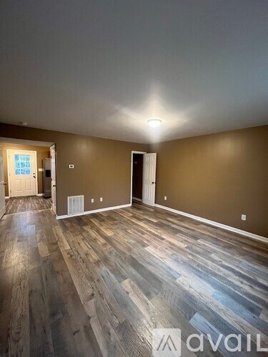 A room with wooden flooring and two doors.