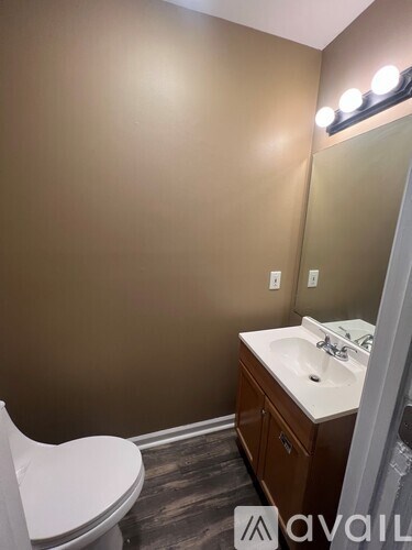 A bathroom with brown walls and a white toilet.