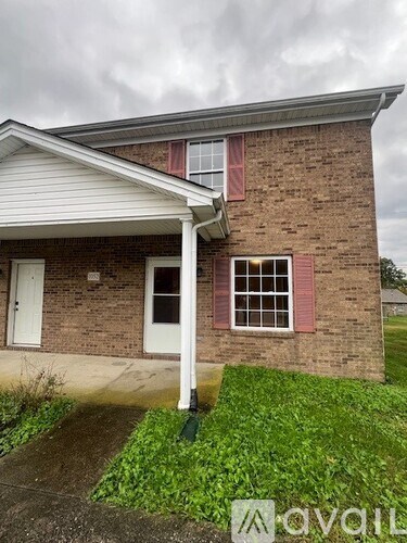 A house with a white door and windows with red trim.