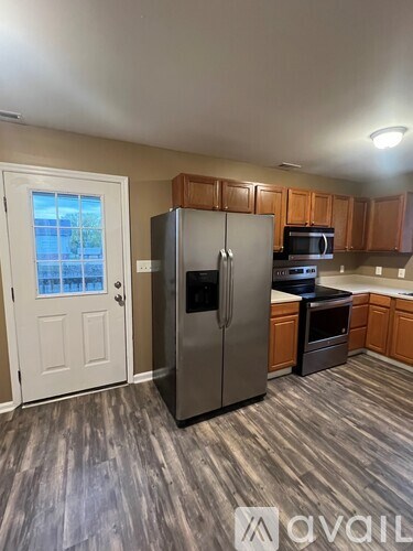 A kitchen with a refrigerator, microwave, and oven.