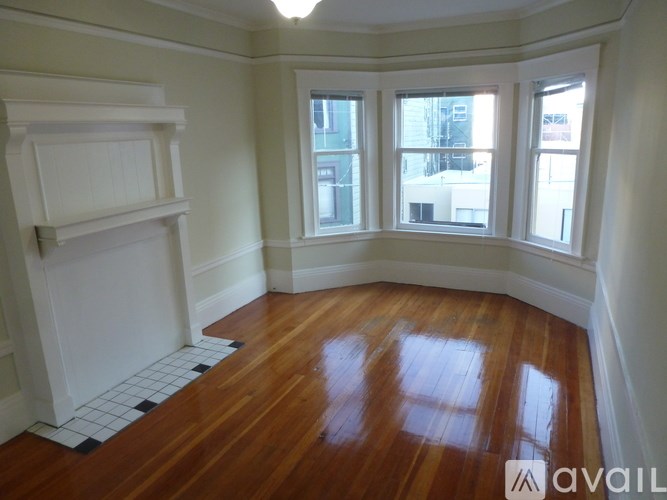 A room with a fireplace and wood flooring.
