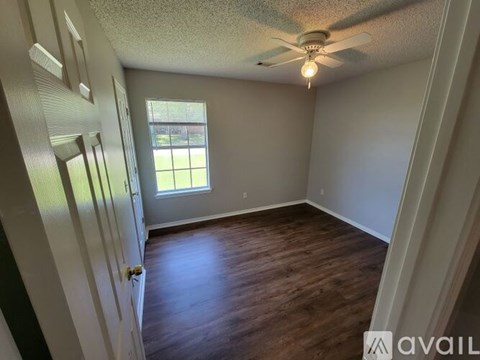 A room with a ceiling fan and a window.
