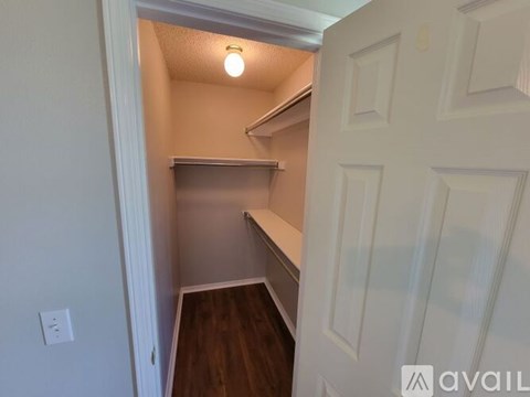 A small, empty room with a door on the right and a light on.