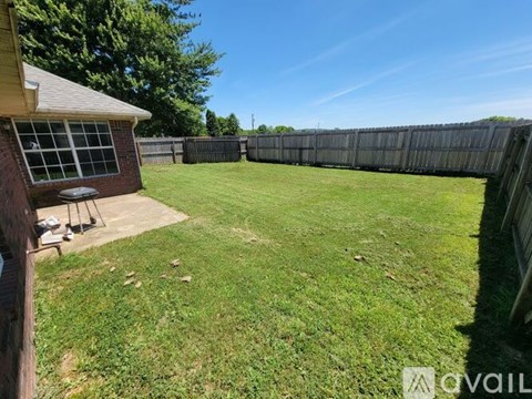 A backyard with a fence and a small building.
