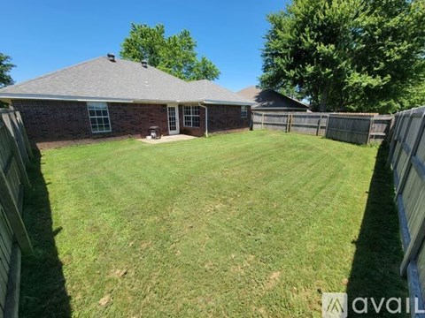A backyard with a house and a fence.