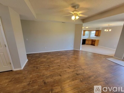 A room with wooden flooring and a ceiling fan.