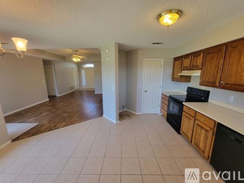 A kitchen with black appliances and wooden cabinets is available for rent.