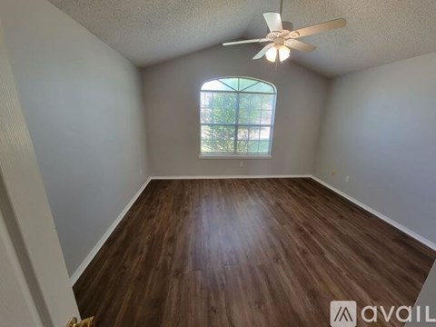 A room with a ceiling fan and a window.