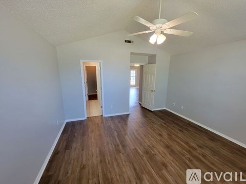 A room with wooden floors and a ceiling fan.