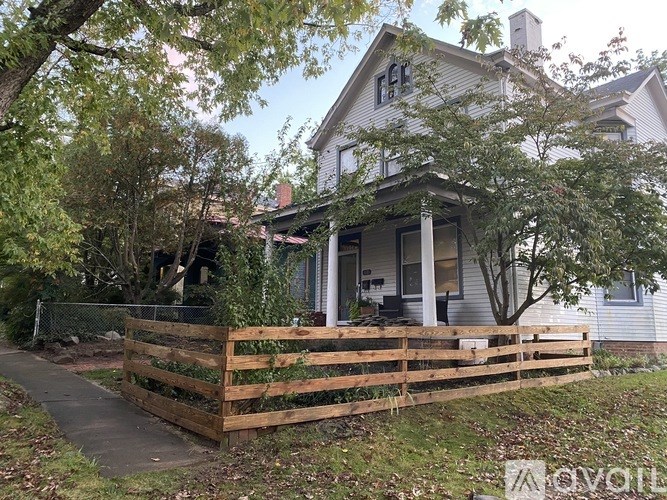 A house with a wooden fence in front of it.