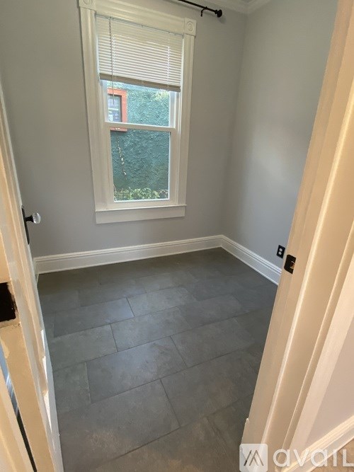 A room with a window and a tiled floor.