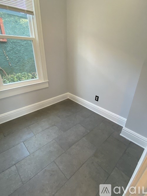 A room with a window and a tiled floor.