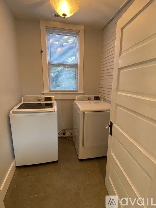 A small bathroom with a toilet and a washing machine.