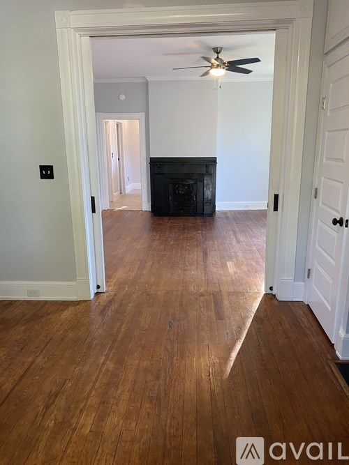 A room with a wooden floor and a fireplace.