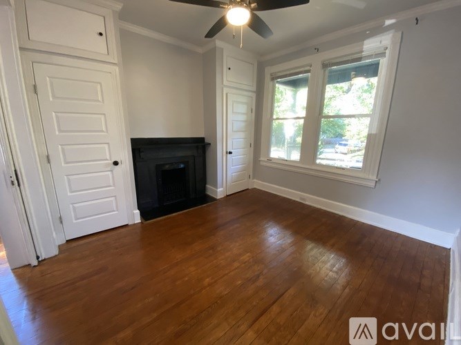 A room with a fireplace and a ceiling fan.