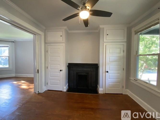 A living room with a fireplace and a ceiling fan.