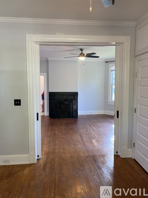A room with a wooden floor and a ceiling fan.