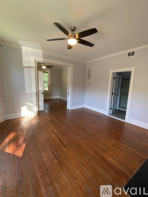 A room with wooden floors and a ceiling fan.