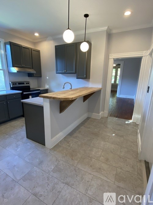 A kitchen with a wooden island in the middle.