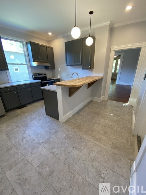 A kitchen with a tiled floor and a wooden island.
