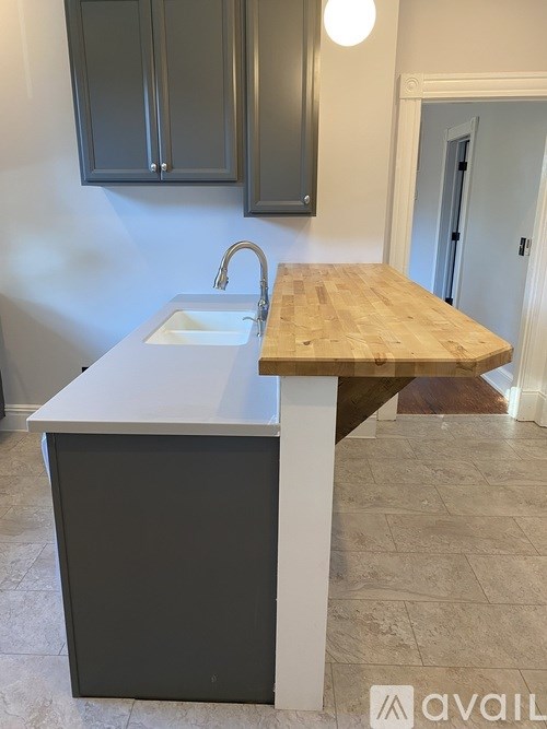 A kitchen with a sink and wooden countertop.