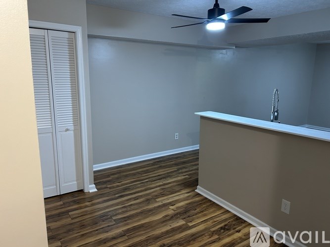 A room with a ceiling fan and wooden flooring.