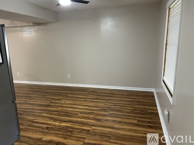 A room with wooden flooring and white walls.