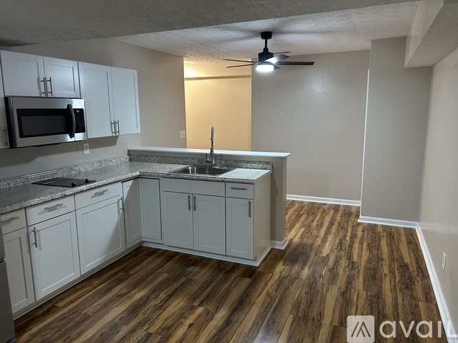 A kitchen with wooden floors and white cabinets.