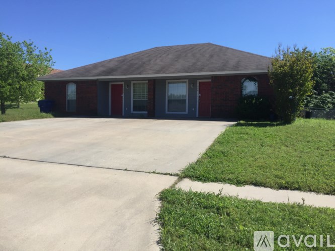 A house with a red door and a driveway in front.