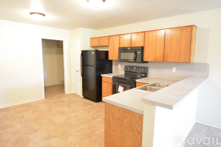 A kitchen with black appliances and wooden cabinets.