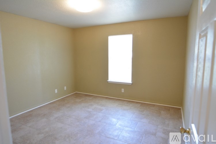 A room with a window and a tiled floor.