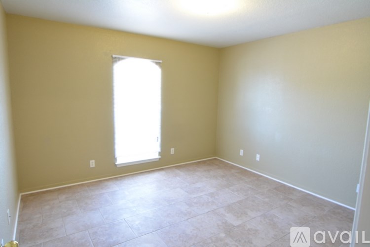 A room with a window and a tiled floor.