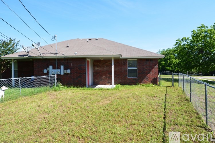 A house with a fence and a dog in front.