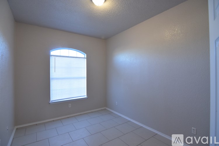 A room with a window and a tiled floor.
