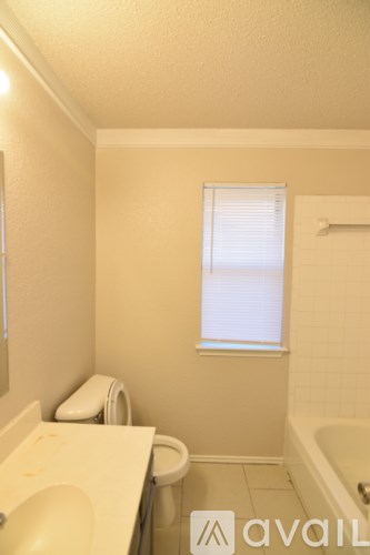 A bathroom with a toilet, sink, and bathtub.