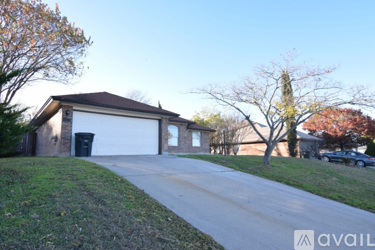 A house with a driveway and a tree with red leaves.