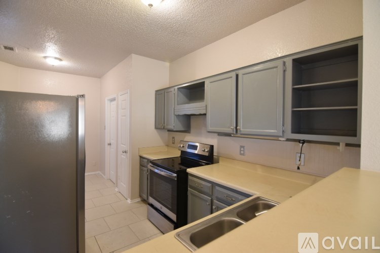 A kitchen with a black refrigerator, microwave, and oven.