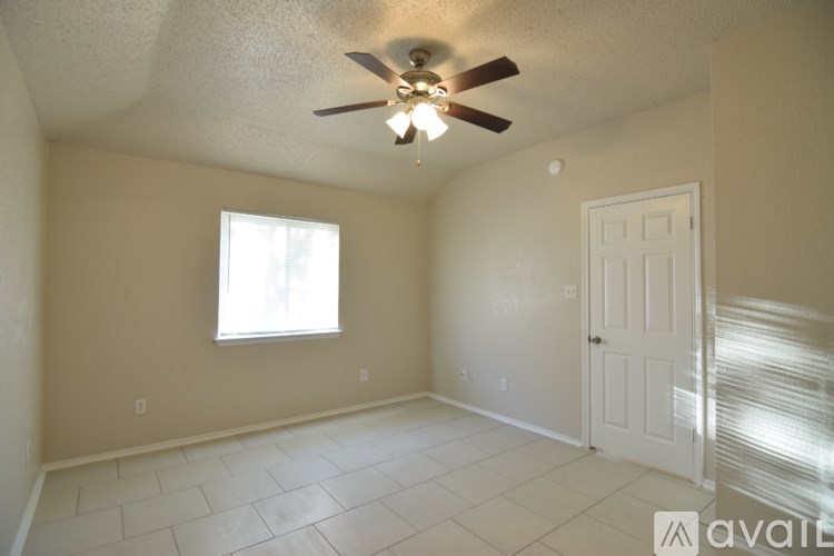 A room with a ceiling fan and a window.