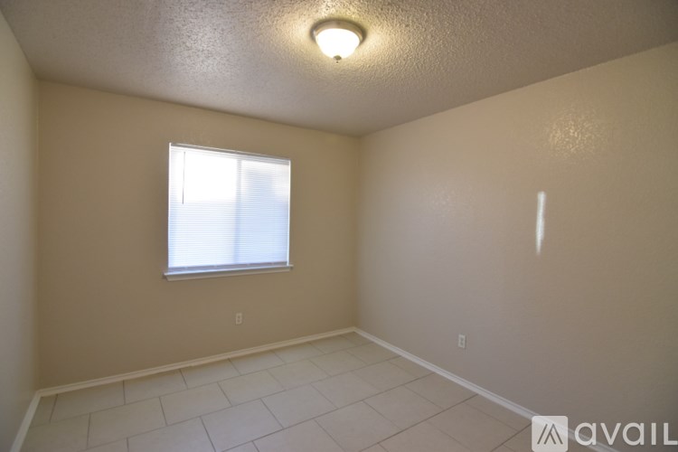 A room with a window and a tiled floor.