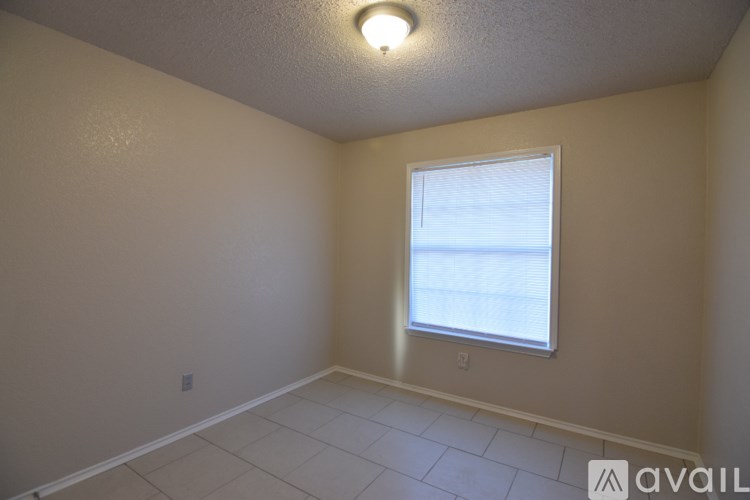 A room with a window and a ceiling light.