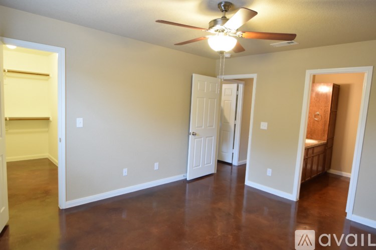 A room with a ceiling fan and a door.
