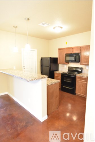 A kitchen with black appliances and wooden cabinets.