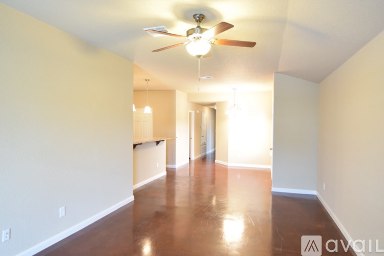 A long hallway with a fan and light on the ceiling.