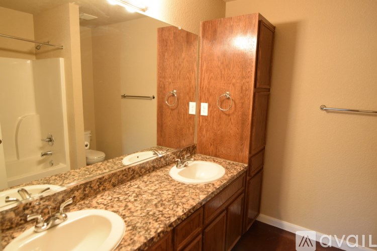 A bathroom with a granite countertop and a wooden medicine cabinet.