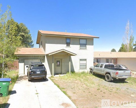 A house with a garage and a truck parked in front.