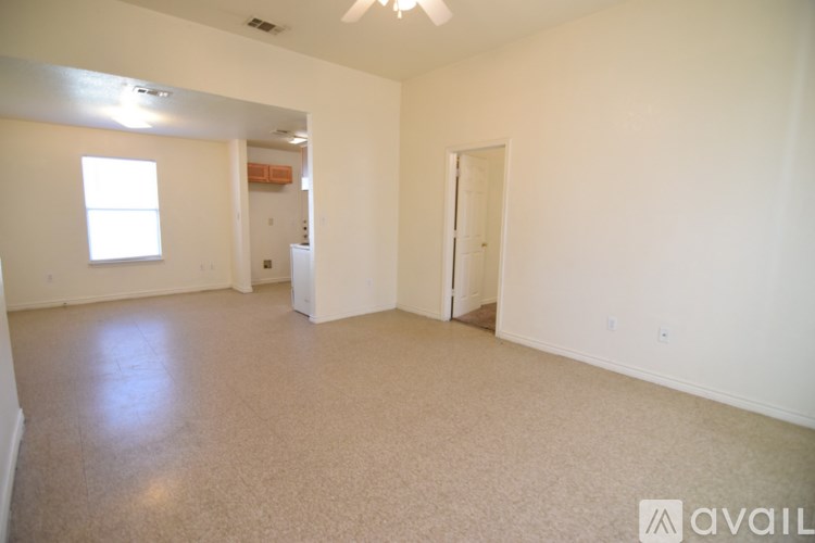 A spacious room with a window, a door, and a refrigerator.